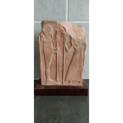 Egyptische steen met hyrogliefen op houten plaat.
