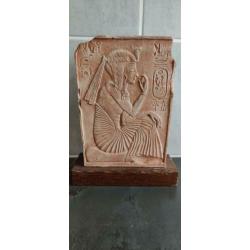 Egyptische steen met hyrogliefen op houten plaat.
