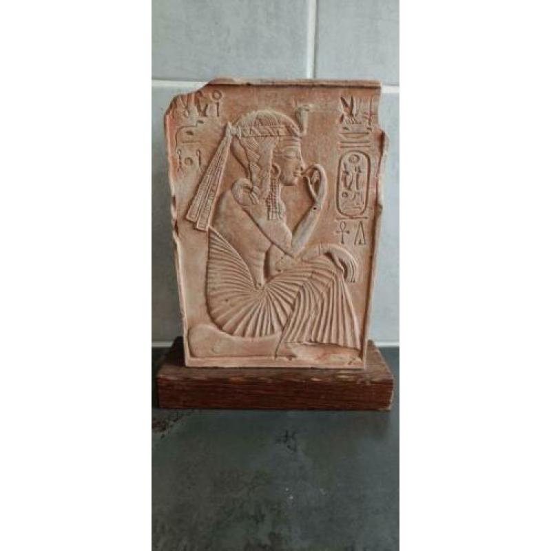 Egyptische steen met hyrogliefen op houten plaat.