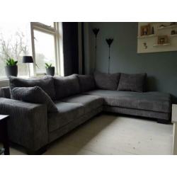 Grijze Ribstoffen hoekbank met lounge.